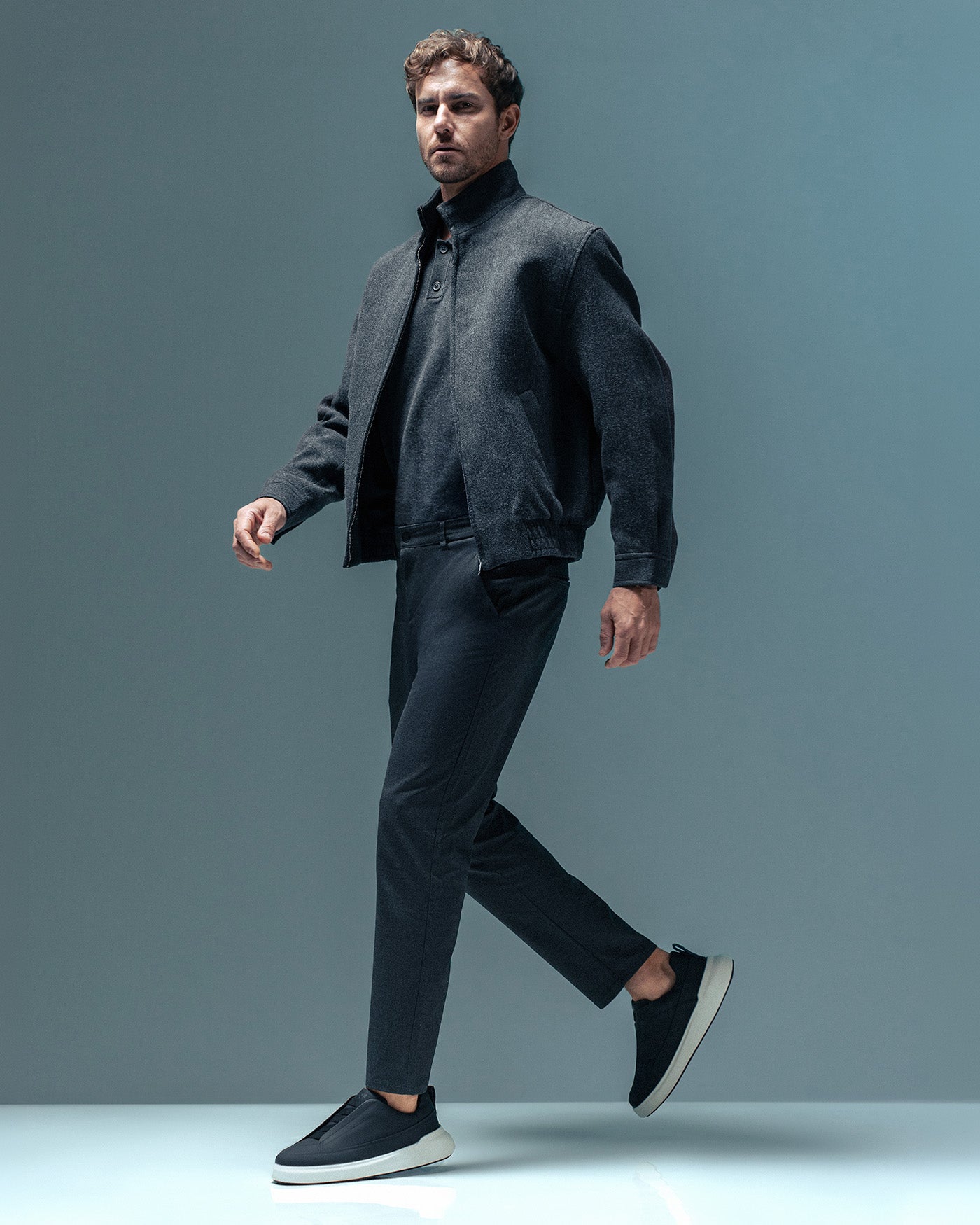 Homem em movimento usando RS7 GT preto com solado claro.